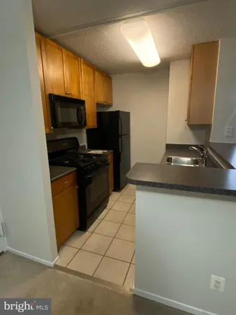 a kitchen with stainless steel appliances a stove a refrigerator a sink a counter top space and cabinets