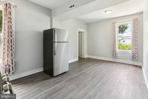 a view of a kitchen with wooden floor and a refrigerator