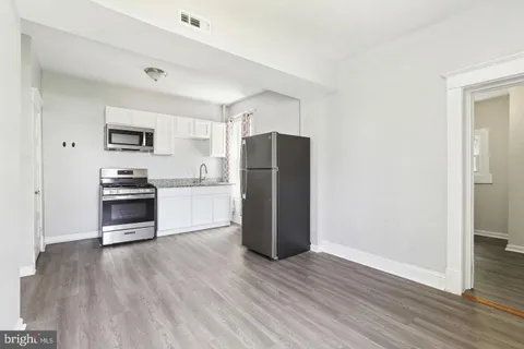 a kitchen with a refrigerator and a stove top oven