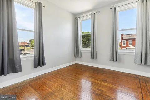 a view of a hallway with wooden floor and a living room