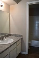 5625 Antoine Drive, Unit 1604 Houston, TX 77091 - Photo 2 of 7 a bathroom with a granite countertop sink and a mirror