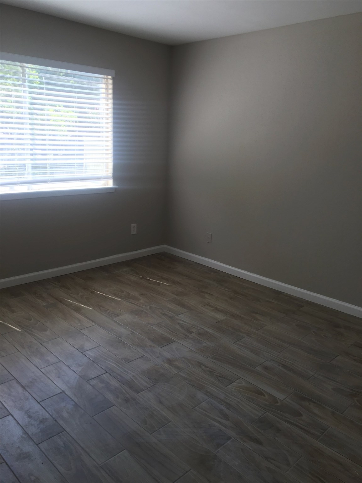 5625 Antoine Drive, Unit 1604 Houston, TX 77091 - Photo 3 of 7 an empty room with wooden floor and windows