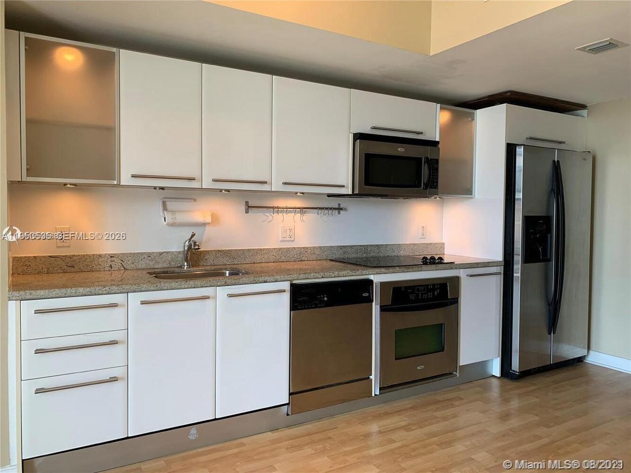 185 Southwest 7th Street, Unit 3706 Miami, FL 33130 - Photo 12 of 26 a kitchen with stainless steel appliances granite countertop a stove and a microwave