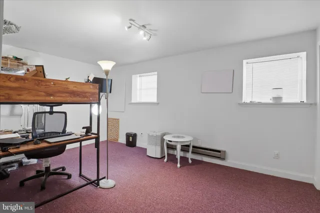 a view of a workspace with furniture and a ceiling fan