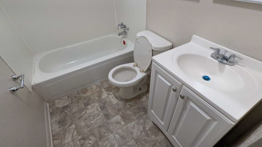 215 Blackshear Street Tomball, TX 77375 - Photo 11 of 12 a bathroom with a sink and a toilet