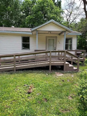 a view of house with backyard and sitting area