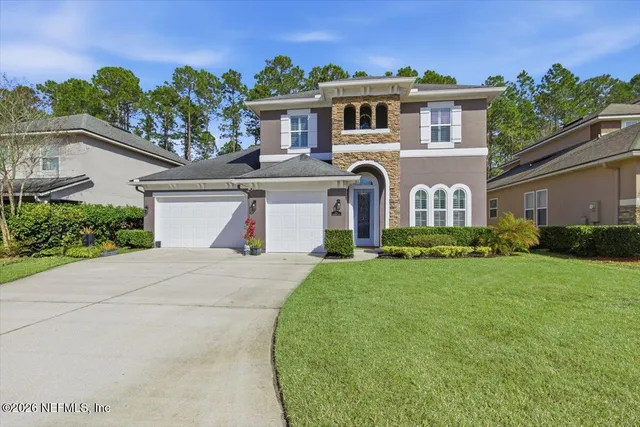 a front view of a house with a yard and garage