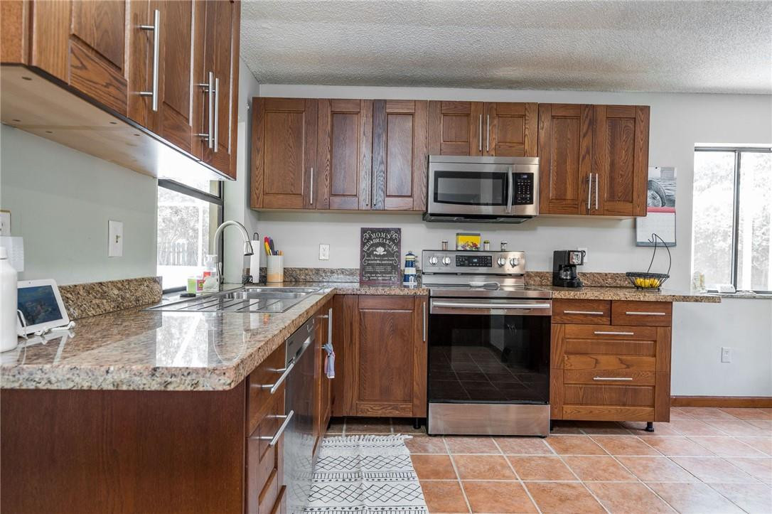 22534 Southwest 7th Street Boca Raton, FL 33433 - Photo 8 of 35 a kitchen with stainless steel appliances granite countertop a stove sink microwave and cabinets