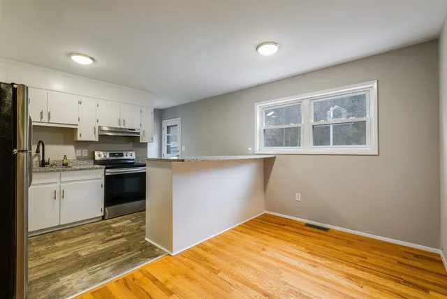 a kitchen with granite countertop a refrigerator stove top oven and sink