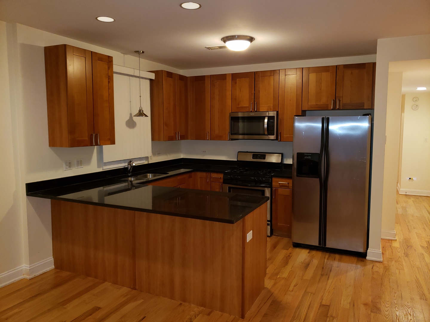 27 East 26th Street, Unit 3 Chicago, IL 60616 - Photo 5 of 17 a kitchen with kitchen island granite countertop a sink and refrigerator