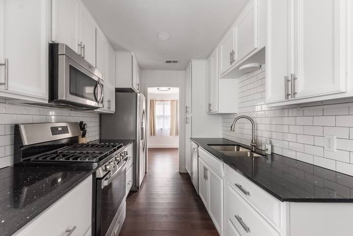 5700 Signal Point Austin, TX 78724 - Photo 3 of 16 Kitchen featuring appliances with stainless steel finishes, dark wood-style floors, white cabinets, and backsplash