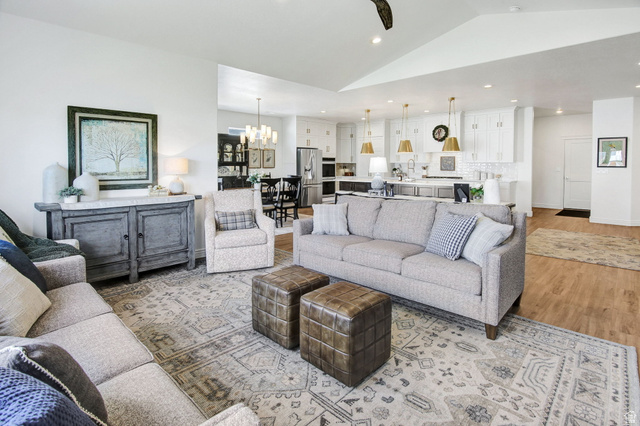 910 South 1700 West Layton, UT 84041 - Photo 10 of 26 Living area with light wood-style flooring, lofted ceiling, and a chandelier