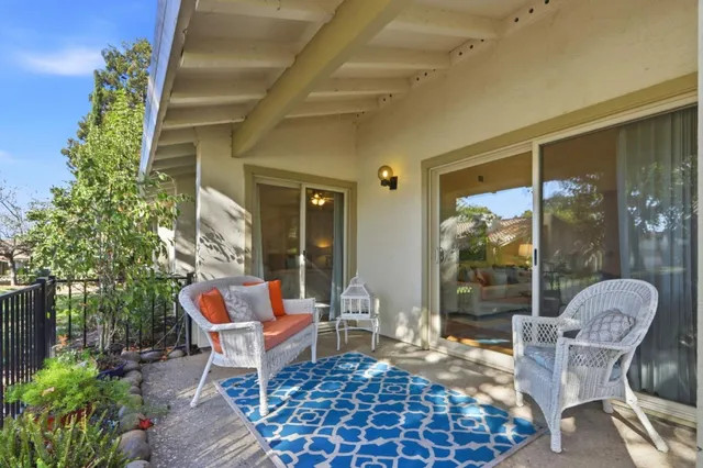 a view of a patio with couches table and chairs and potted plants