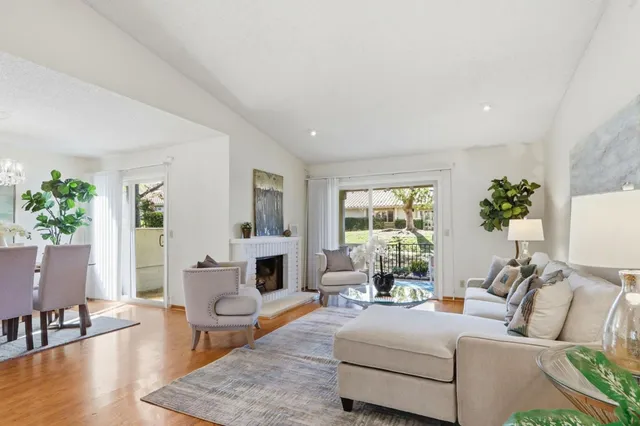 a living room with furniture fireplace and a large window