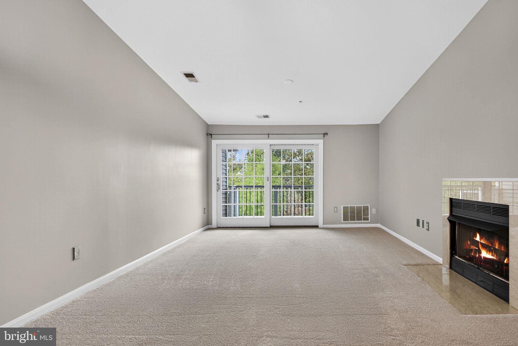 44084 Natalie Terrace, Unit 301 Ashburn, VA 20147 - Photo 13 of 59 a view of an empty room with a fireplace