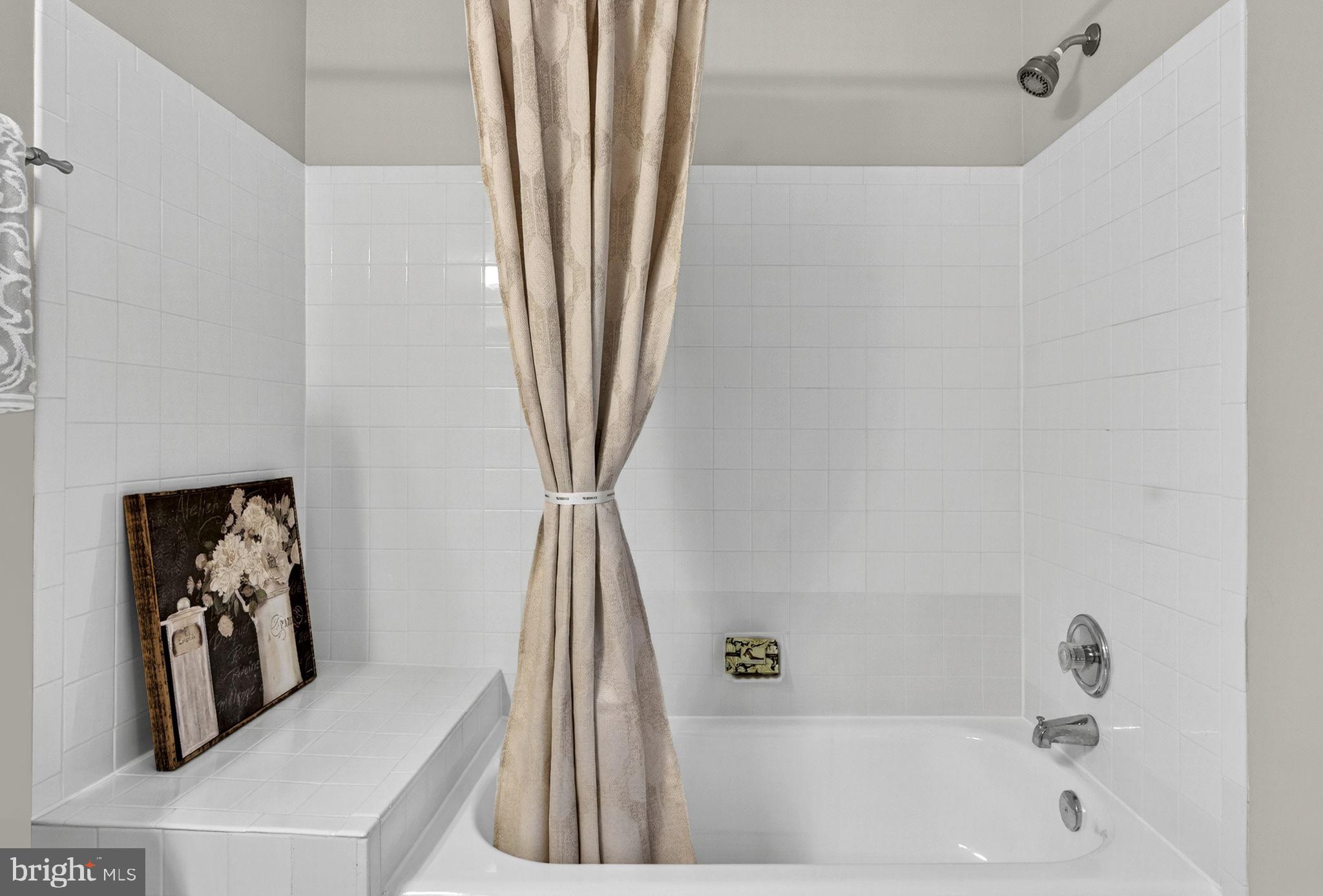 44084 Natalie Terrace, Unit 301 Ashburn, VA 20147 - Photo 24 of 59 a bathroom with a bathtub sink and a shower