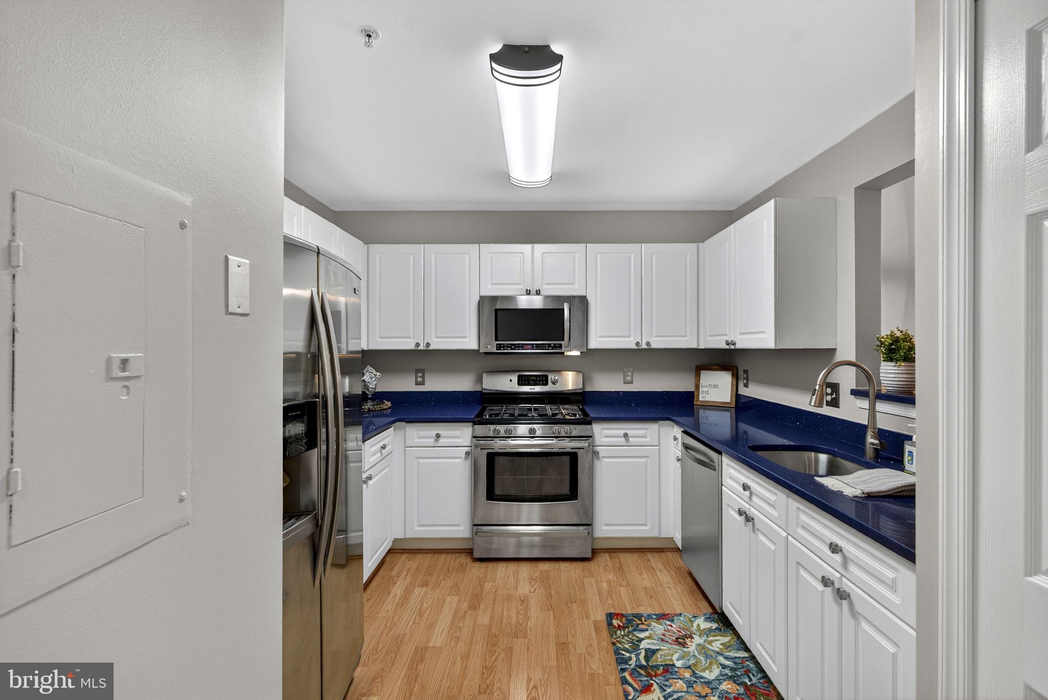 44084 Natalie Terrace, Unit 301 Ashburn, VA 20147 - Photo 31 of 59 a kitchen with stainless steel appliances granite countertop a stove a sink and a refrigerator