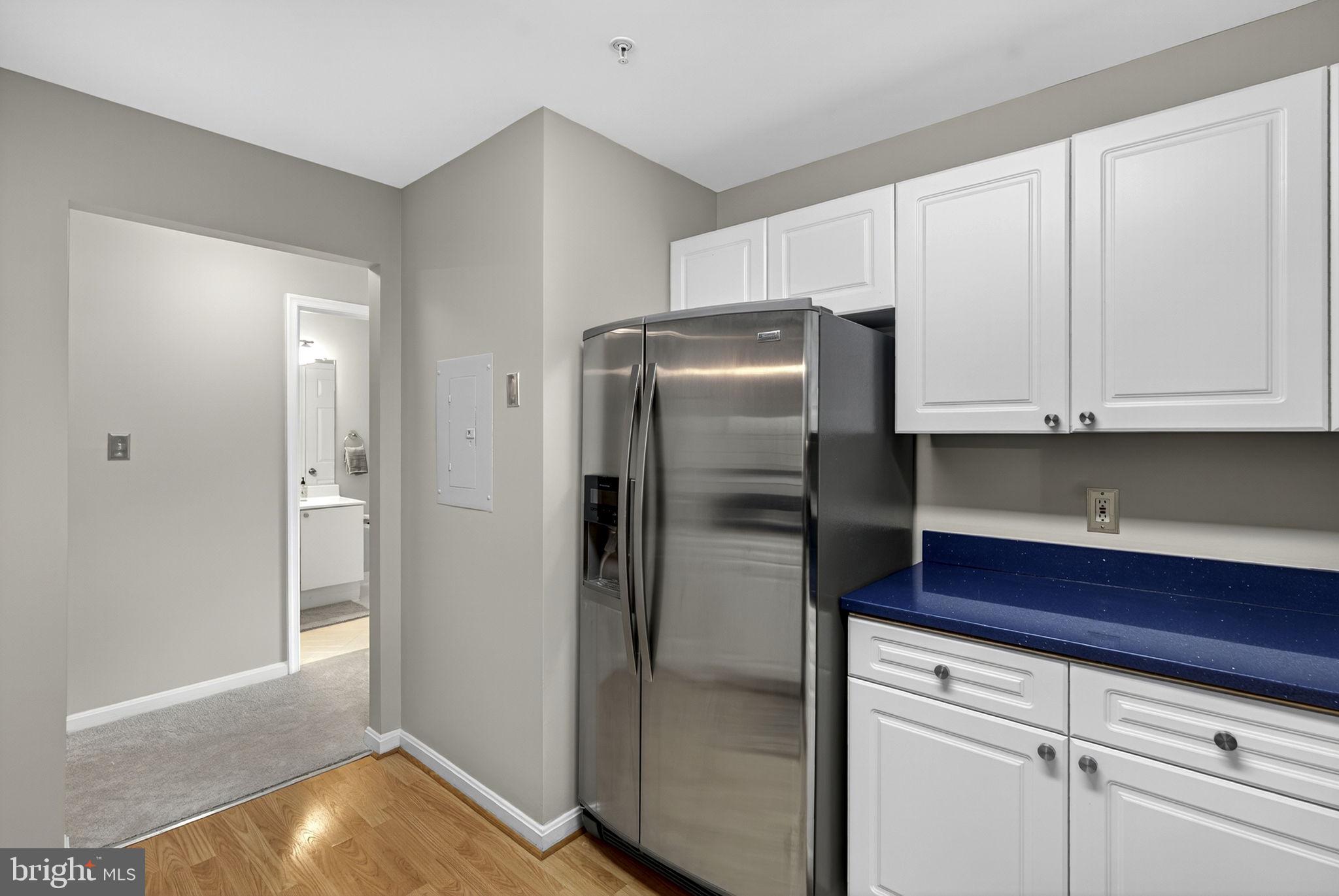 44084 Natalie Terrace, Unit 301 Ashburn, VA 20147 - Photo 38 of 59 a kitchen with a refrigerator and cabinets