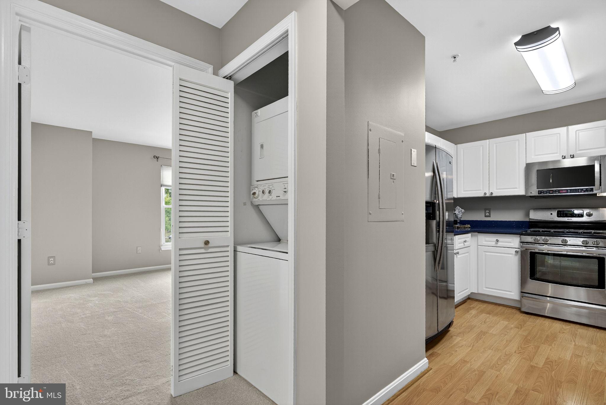 44084 Natalie Terrace, Unit 301 Ashburn, VA 20147 - Photo 39 of 59 a kitchen with white cabinets and stainless steel appliances