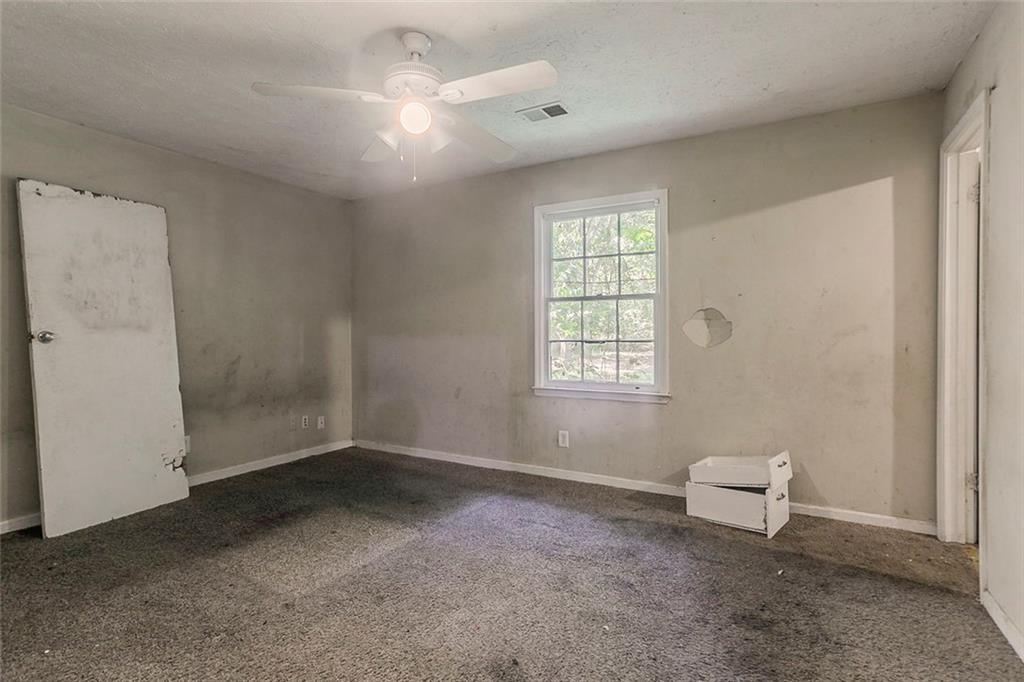 926 Bell Road Southeast Conyers, GA 30094 - Photo 15 of 32 an empty room with windows and fan
