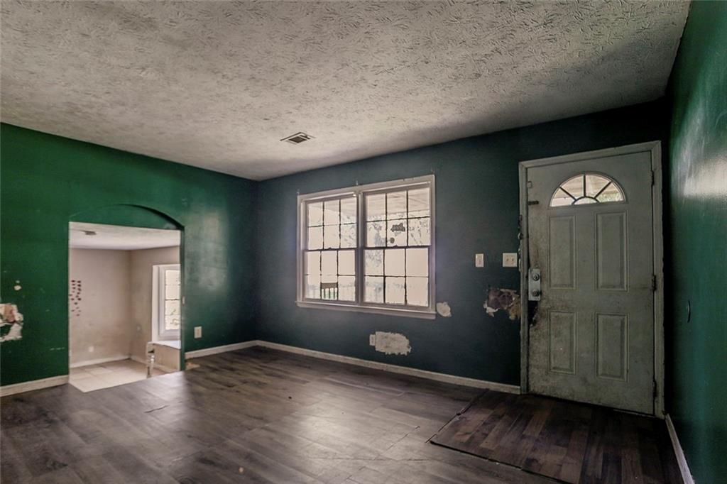 926 Bell Road Southeast Conyers, GA 30094 - Photo 5 of 32 an empty room with wooden floor and windows