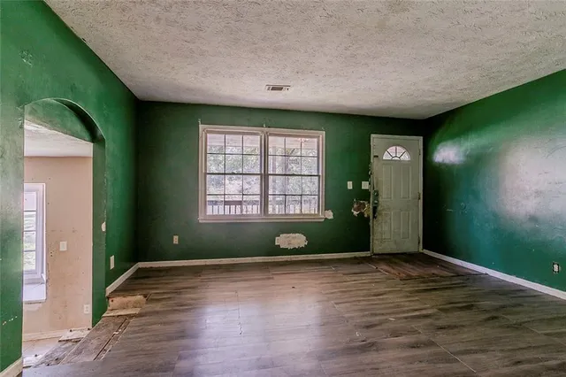 a view of an empty room with window wooden floor and windows