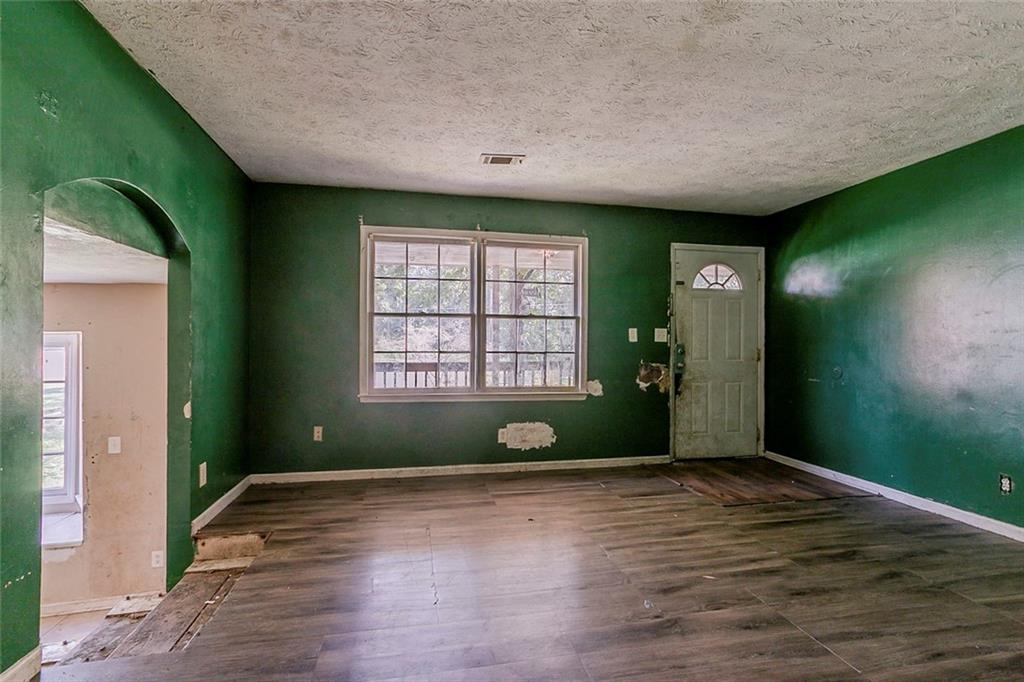 926 Bell Road Southeast Conyers, GA 30094 - Photo 7 of 32 a view of an empty room with window wooden floor and windows