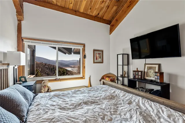 a bedroom with a bed and a flat tv screen on the dresser