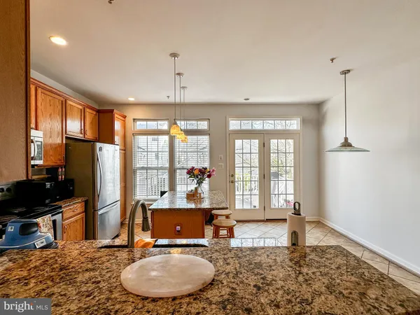 a living room with kitchen appliances furniture and a large window
