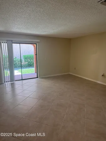 an empty room with floor to ceiling window and an outdoor view