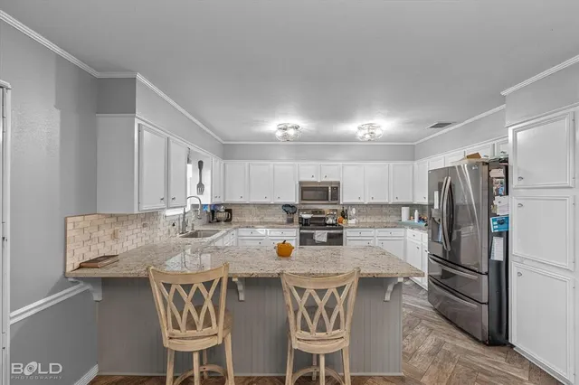 a kitchen with cabinets appliances a sink and a window