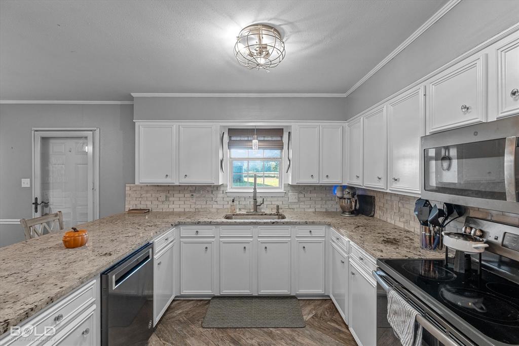 3804 Farmridge Road Keithville, LA 71047 - Photo 25 of 36 a kitchen with a sink stove and cabinets