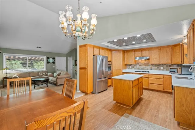 a kitchen with stainless steel appliances granite countertop a sink a stove and a refrigerator
