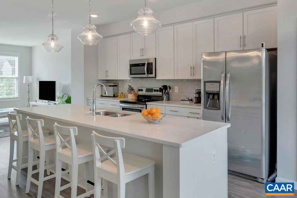 2176 Avinity Loop Charlottesville, VA 22902 - Photo 14 of 50 a kitchen with stainless steel appliances granite countertop a sink a microwave a refrigerator and white cabinets