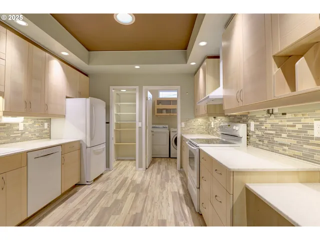 a large kitchen with a sink and refrigerator