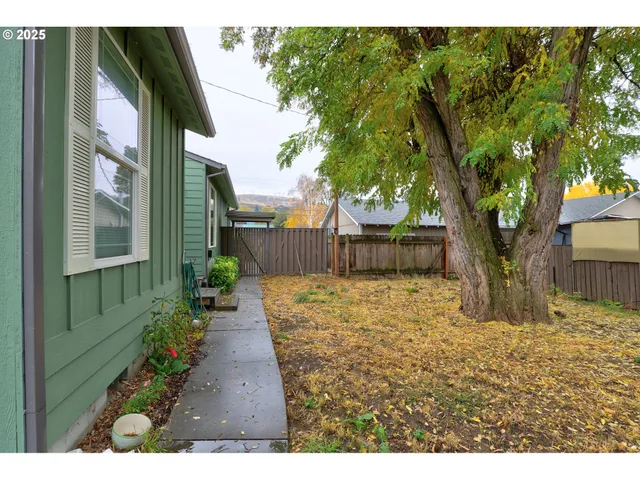 a backyard of a house with table and chairs