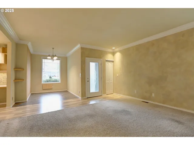 a view of a hallway with wooden floor and a living room