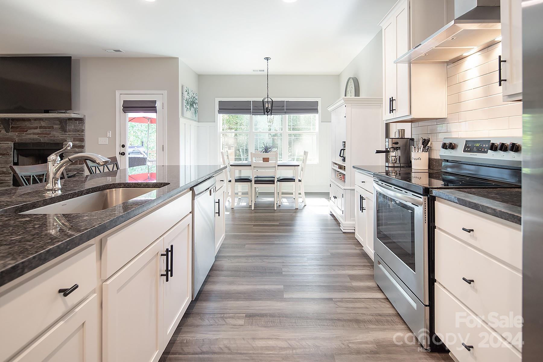 3000 Penninger Road Concord, NC 28025 - Photo 12 of 48 a large kitchen with granite countertop a large counter top space a sink stainless steel appliances and windows