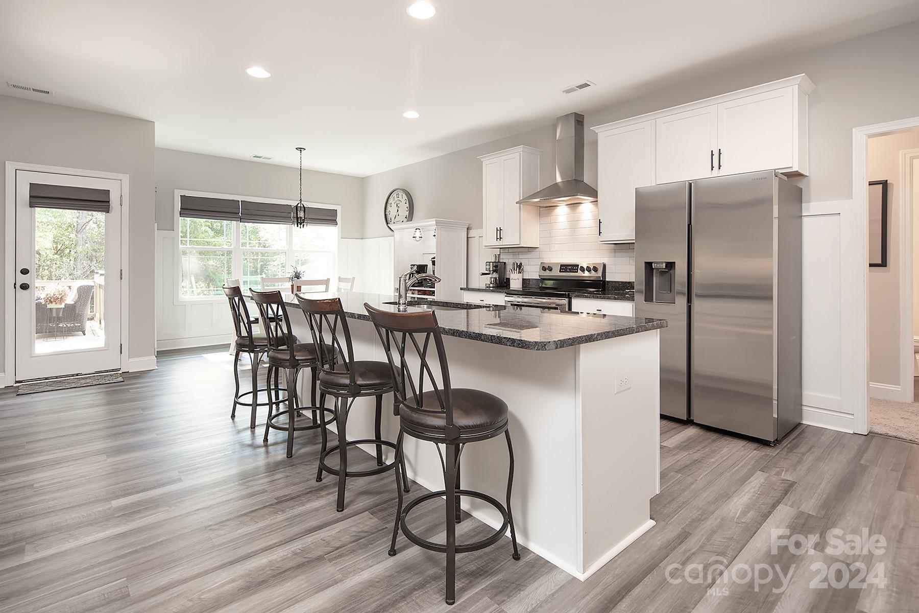 3000 Penninger Road Concord, NC 28025 - Photo 13 of 48 a kitchen with stainless steel appliances granite countertop a dining table chairs refrigerator and cabinets