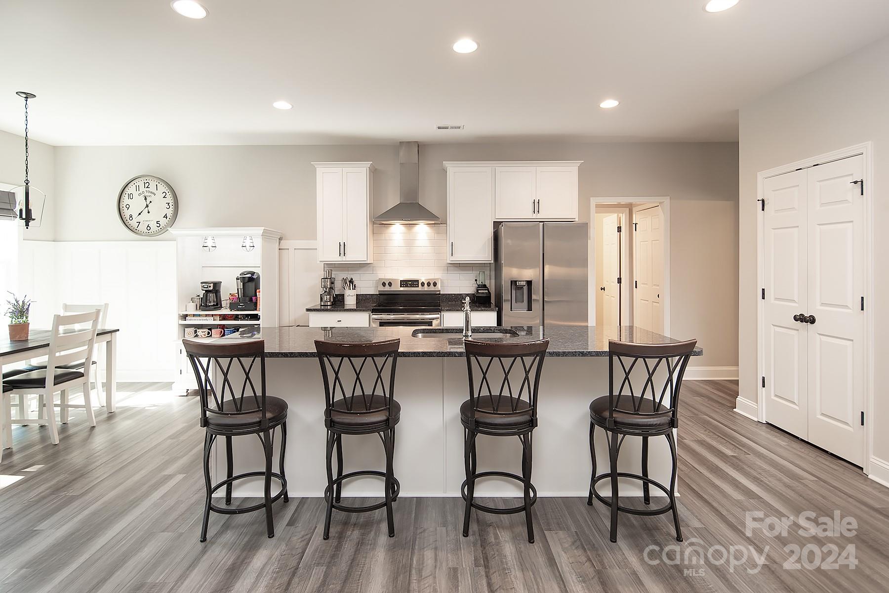 3000 Penninger Road Concord, NC 28025 - Photo 14 of 48 a kitchen with stainless steel appliances a dining table chairs stove and refrigerator