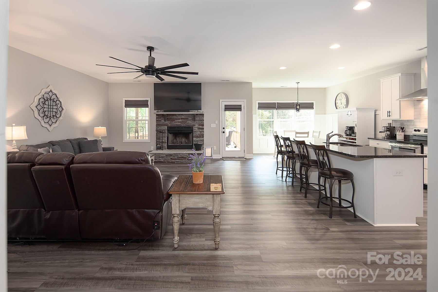 3000 Penninger Road Concord, NC 28025 - Photo 26 of 48 a living room with furniture a fireplace and a dining table with wooden floor