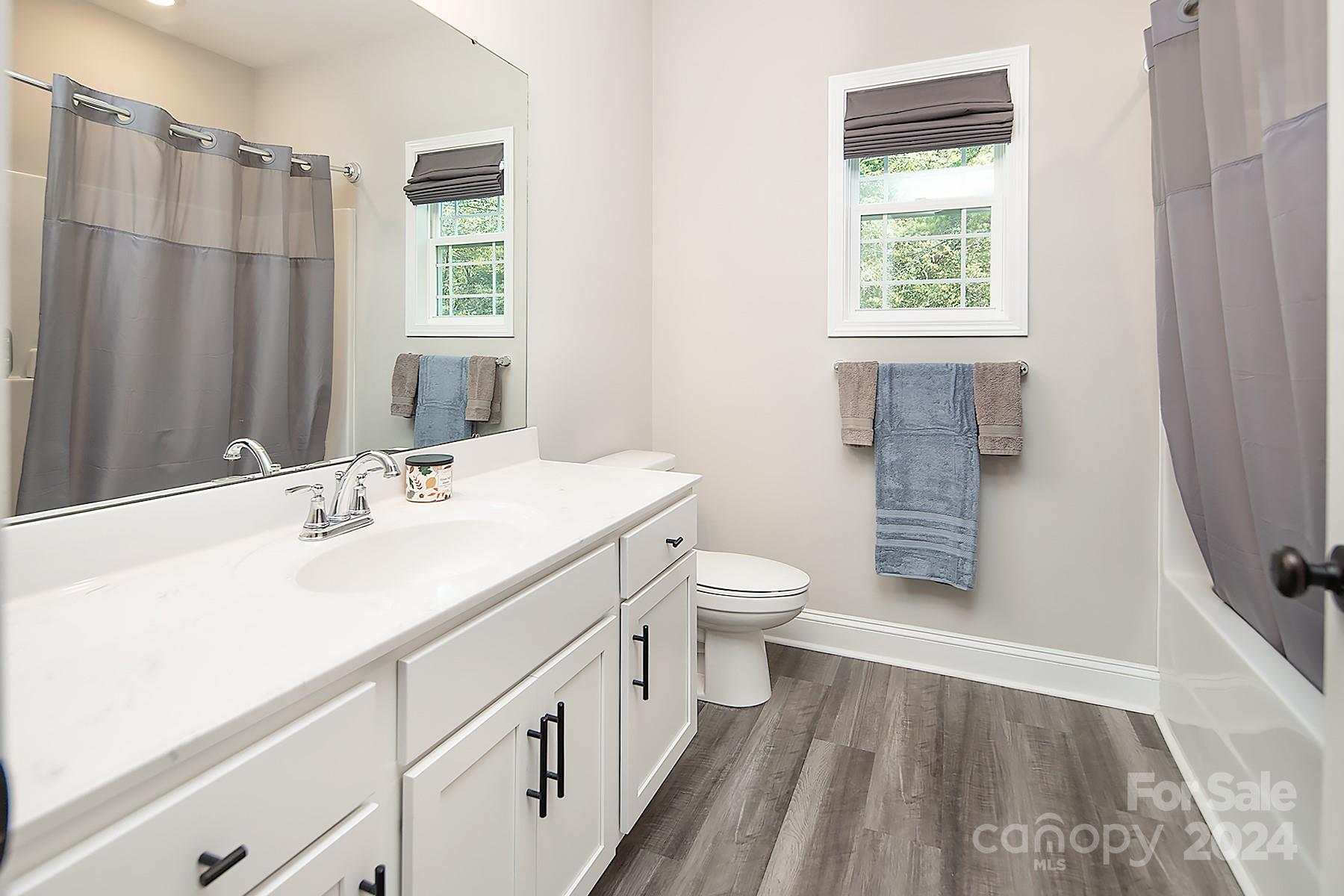 3000 Penninger Road Concord, NC 28025 - Photo 37 of 48 a spacious bathroom with a sink a toilet a window and a mirror