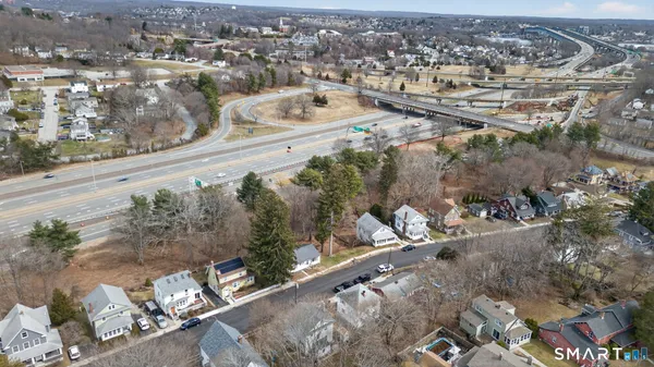 a view of a white house with a large tree