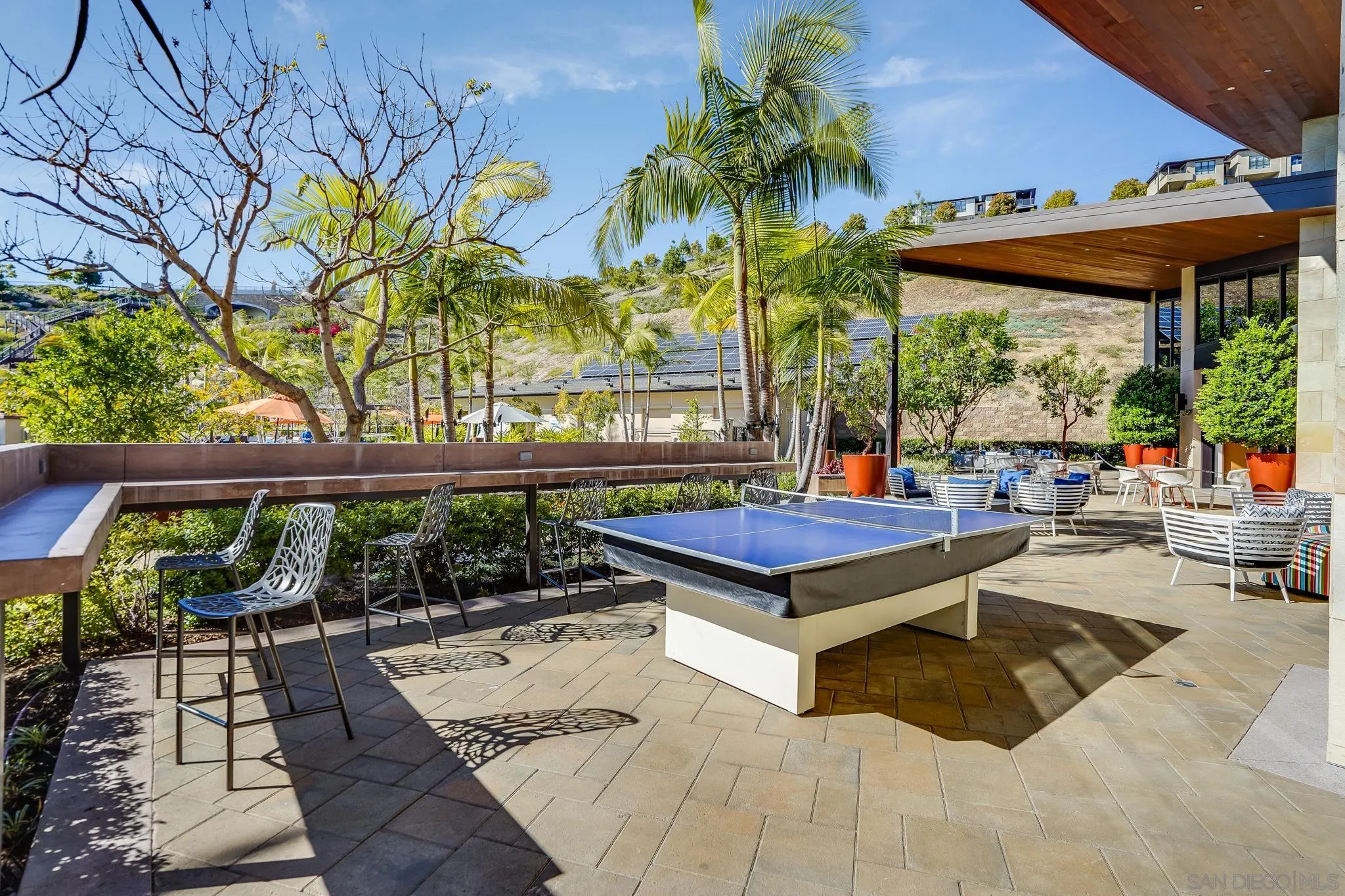 7803 Inception Way San Diego, CA 92108 - Photo 32 of 37 a view of a patio with a table and chairs under an umbrella with a large tree