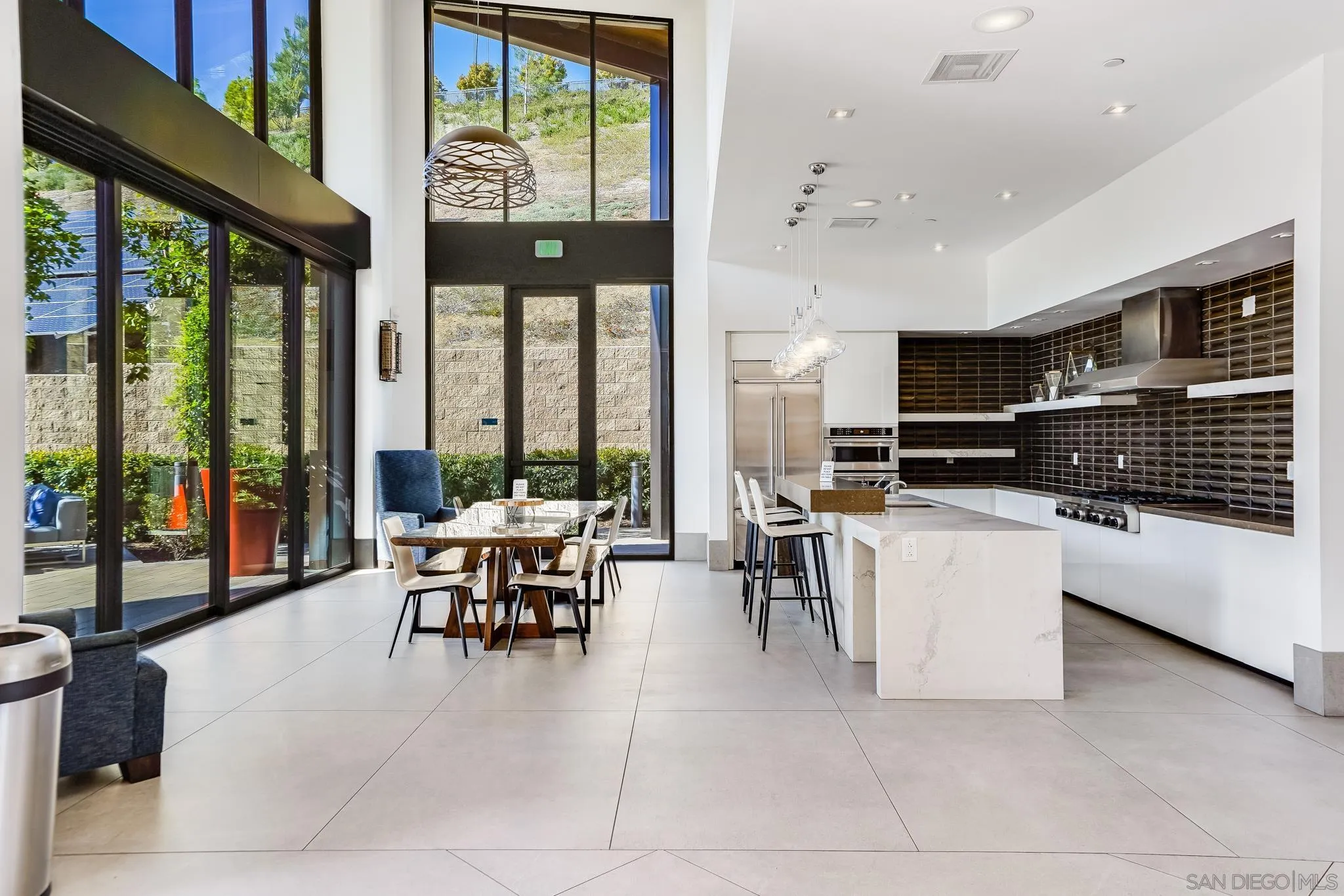 7803 Inception Way San Diego, CA 92108 - Photo 37 of 37 a living room with couches a dining table chairs and a large window