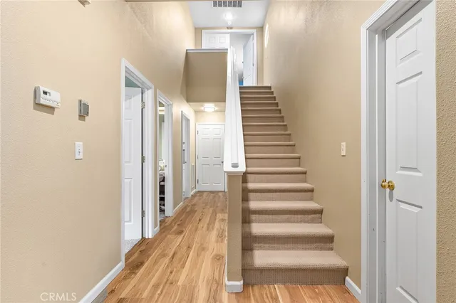 a view of a hallway with wooden floor and entryway