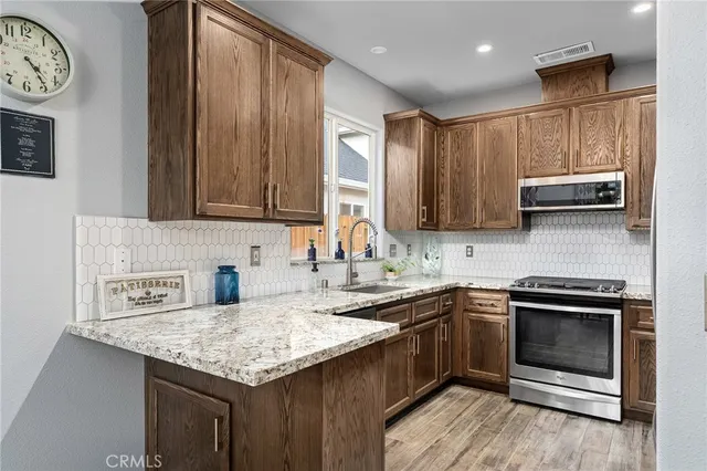 a kitchen with stainless steel appliances granite countertop a sink stove and microwave