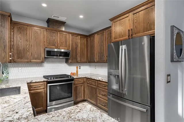 a kitchen with stainless steel appliances granite countertop a refrigerator stove and microwave