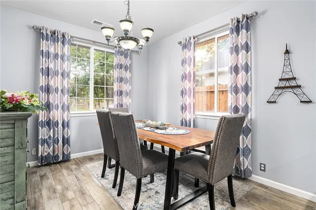 a dining room with furniture a chandelier and window