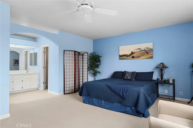 a bedroom with a large bed and a chandelier